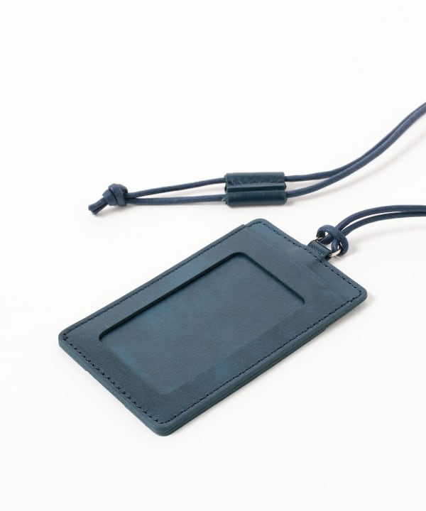 A cow leather pass/card case with a clear ID window and attached neck cord on a white background.