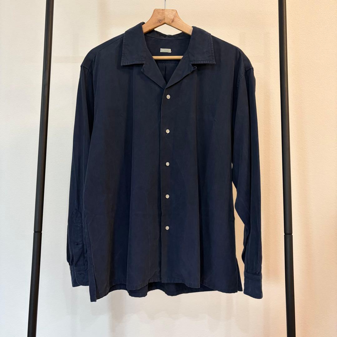 Front view of a dark blue A.PRESSE silk-cotton open-collar men's shirt hanging on a rack.