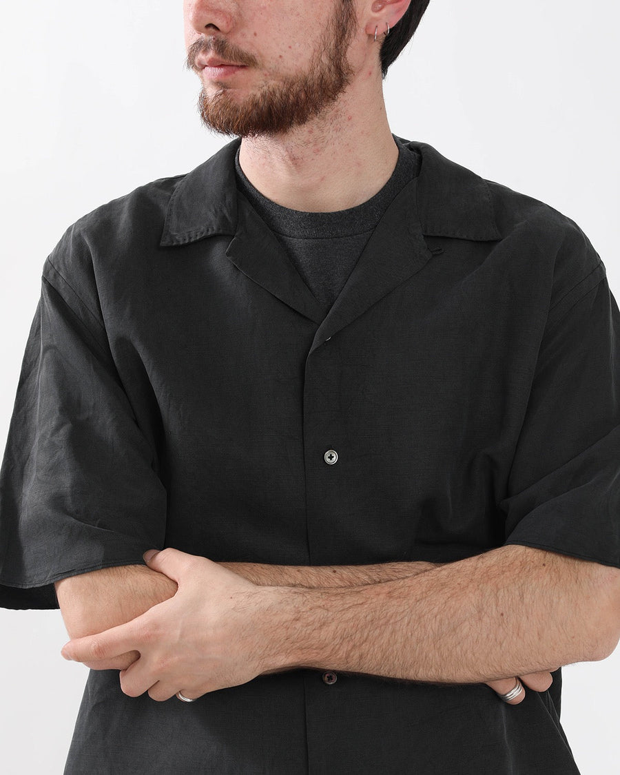 Close-up of a man wearing the A.PRESSE vintage silk-linen short-sleeve open-collar shirt in black.