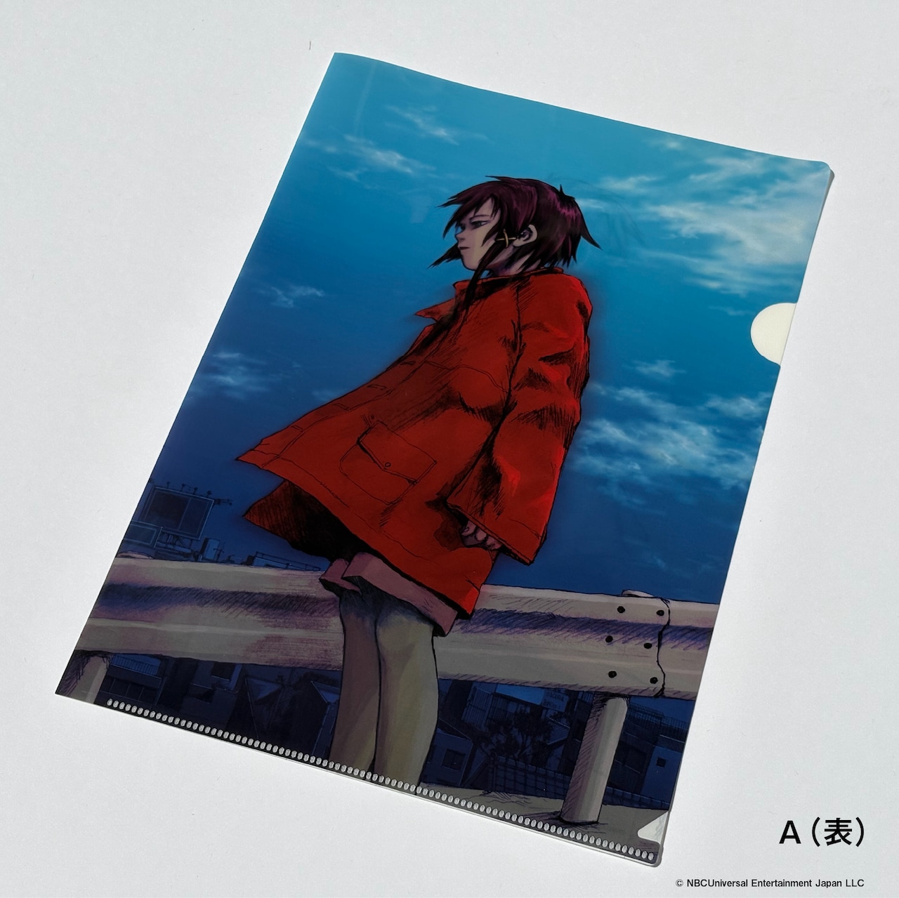Photograph of an A4 clear file folder showing an illustration of a person in a red coat standing by a guardrail against a blue sky.
