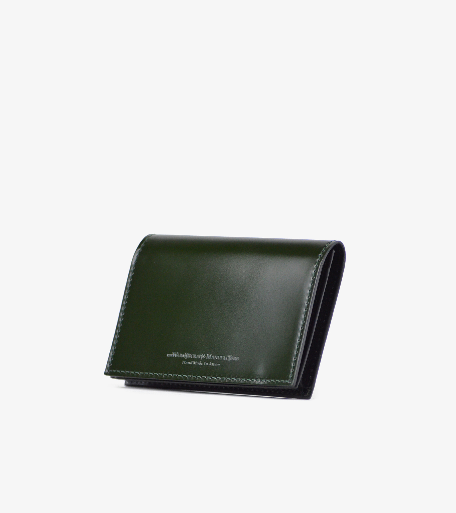 Green cordovan leather card case angled on a white background.