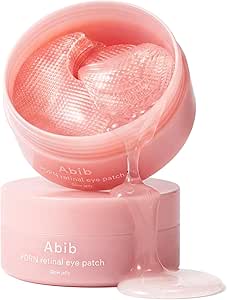 Open pink jar of Abib PDRN eye patches showing translucent crescent gel patches and a drip of liquid.