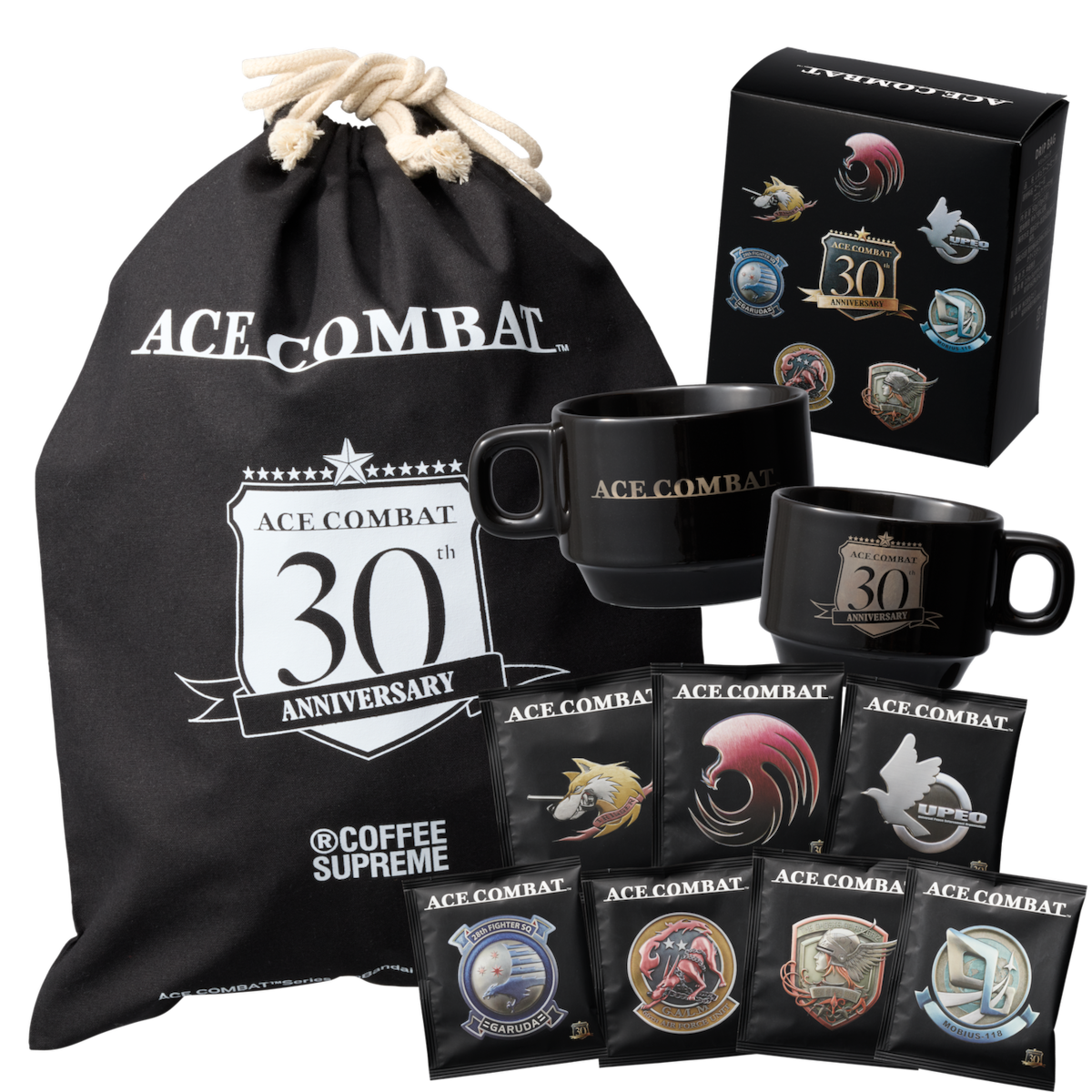 Two black ceramic ACE COMBAT 30th Anniversary mugs displayed with a branded drawstring bag and individual coffee packets.