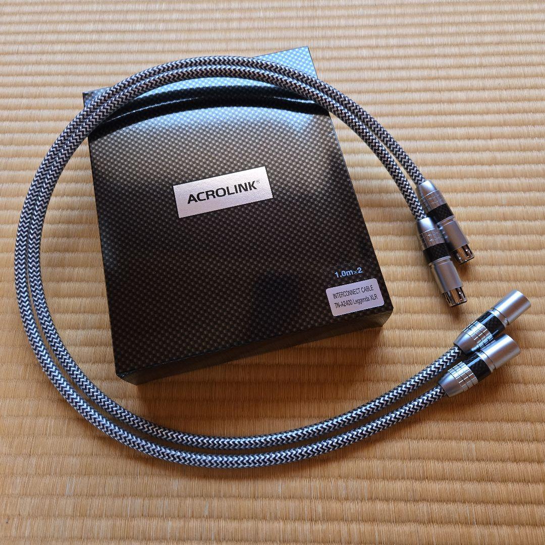 Coiled pair of ACROLINK XLR cables with braided sheath displayed next to the ACROLINK box on a mat.