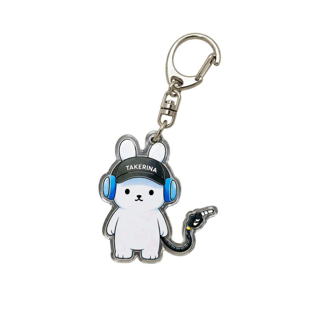 Acrylic keychain showing a white cartoon bear wearing blue headphones and a black cap that reads "TAKERINA", attached to a metal keyring and clasp.