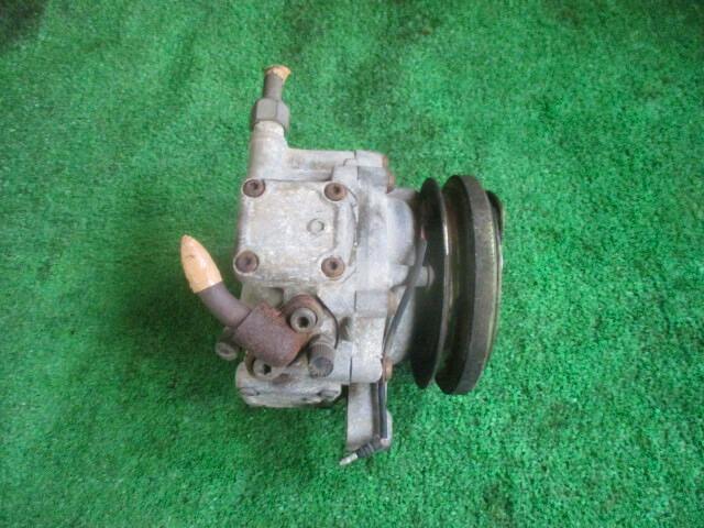 Keihin air conditioning compressor for an Acty TA shown on a green surface.