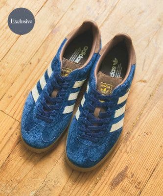 A pair of blue adidas Gazelle Indoor sneakers photographed on a wooden floor.