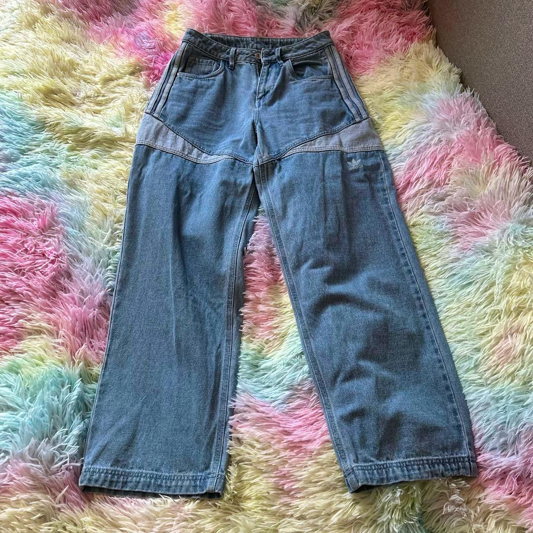 Front view of light blue women's denim jeans laid flat on a multicolored shag rug.