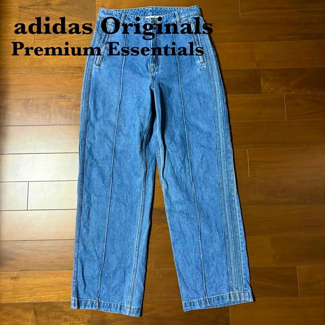 Blue denim women's straight jeans laid flat on a wooden floor, showing front view and stitched seams.