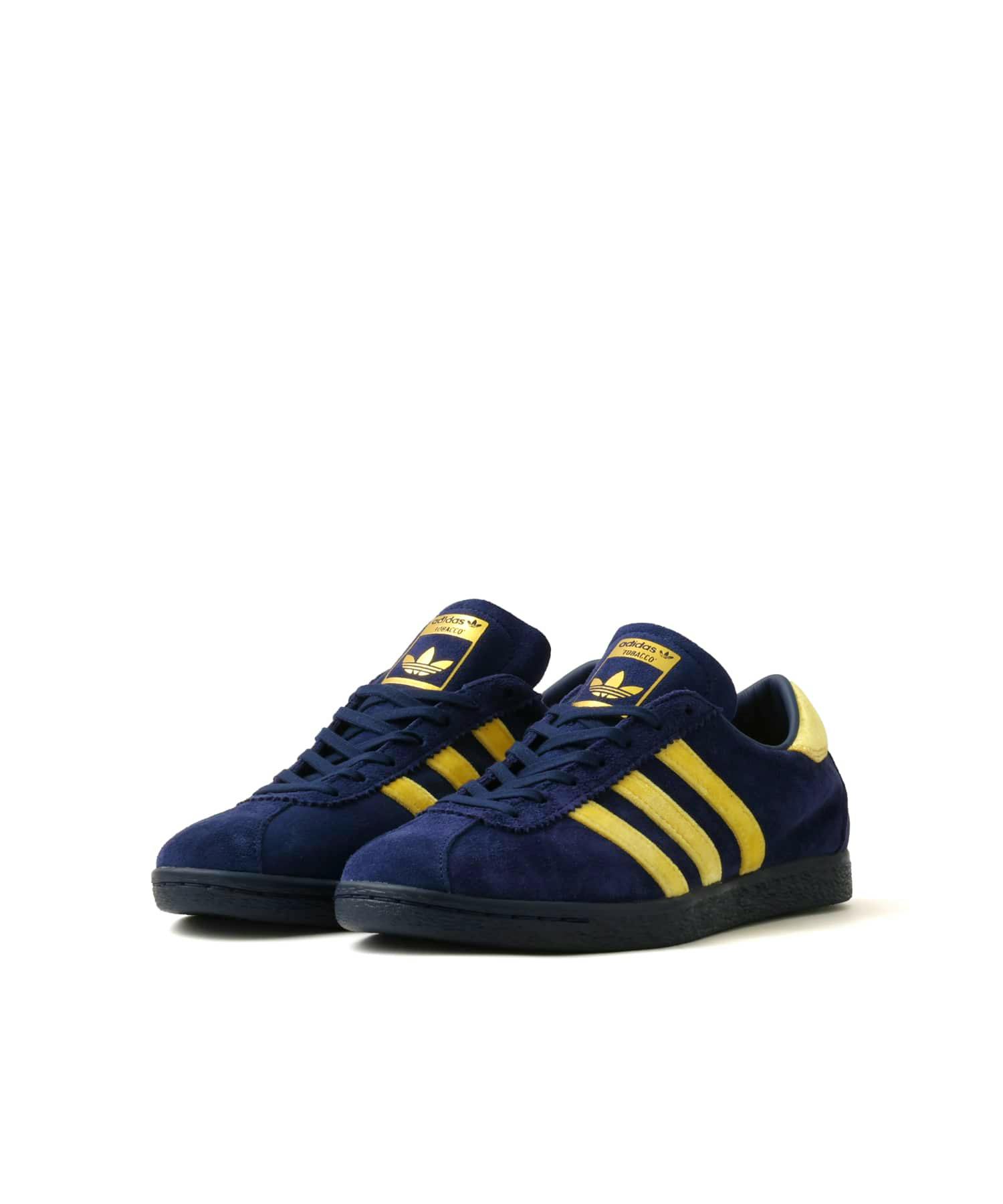 Pair of adidas TOBACCO sneakers in navy and yellow shown on a white background.