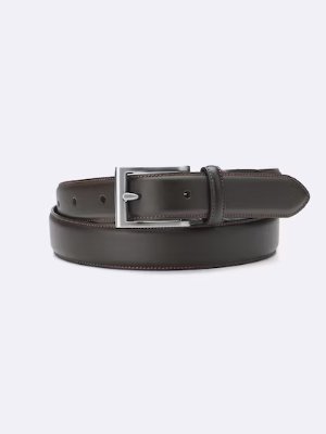 A cow leather belt with a rectangular silver buckle coiled on a plain background.