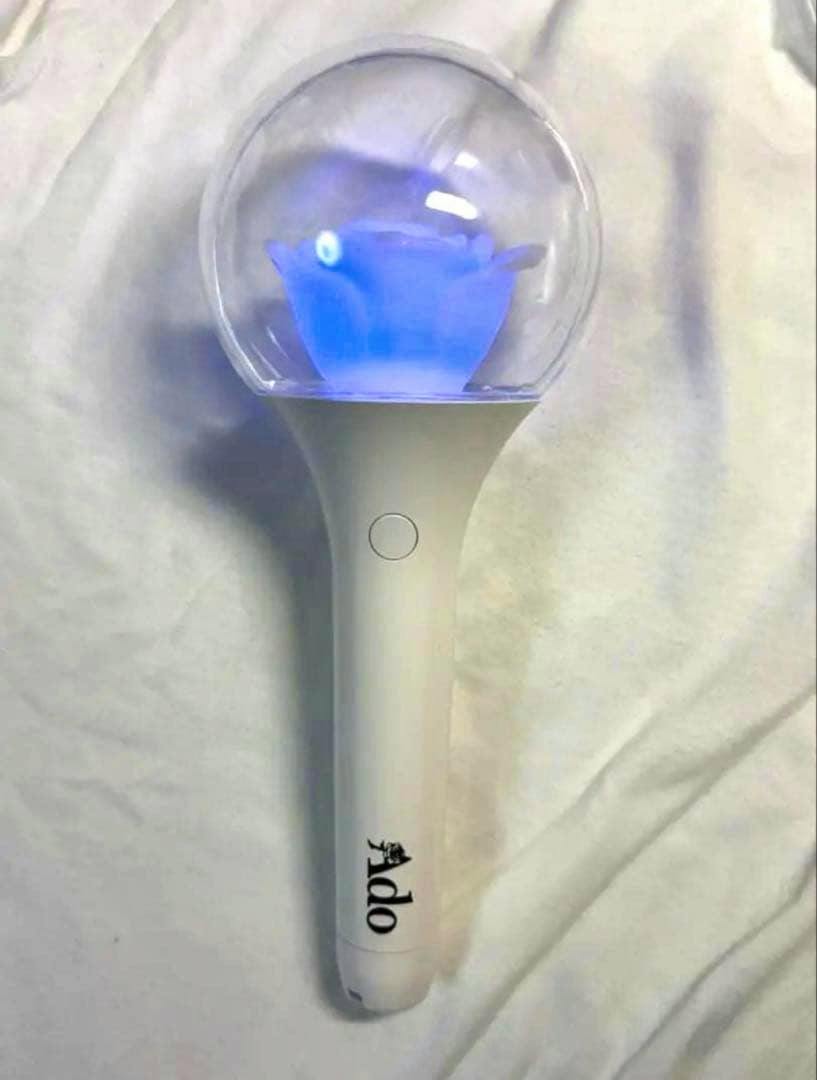 White Ado penlight with a clear globe top glowing blue and the 'Ado' logo on the handle.