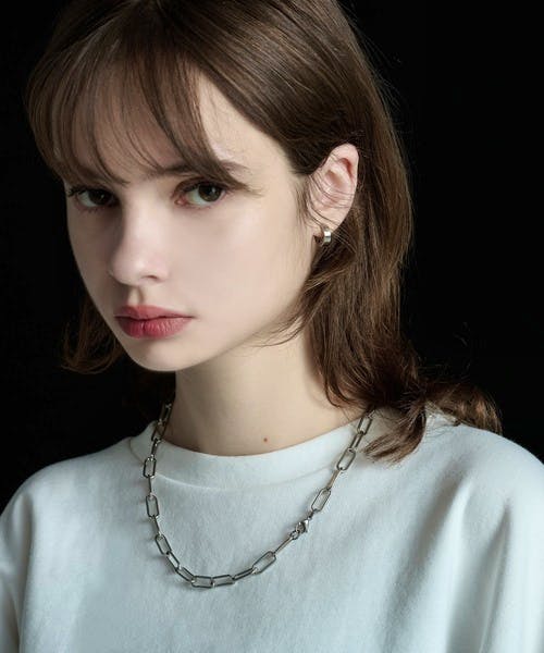 A model wearing a surgical stainless steel chain-link necklace over a white shirt.