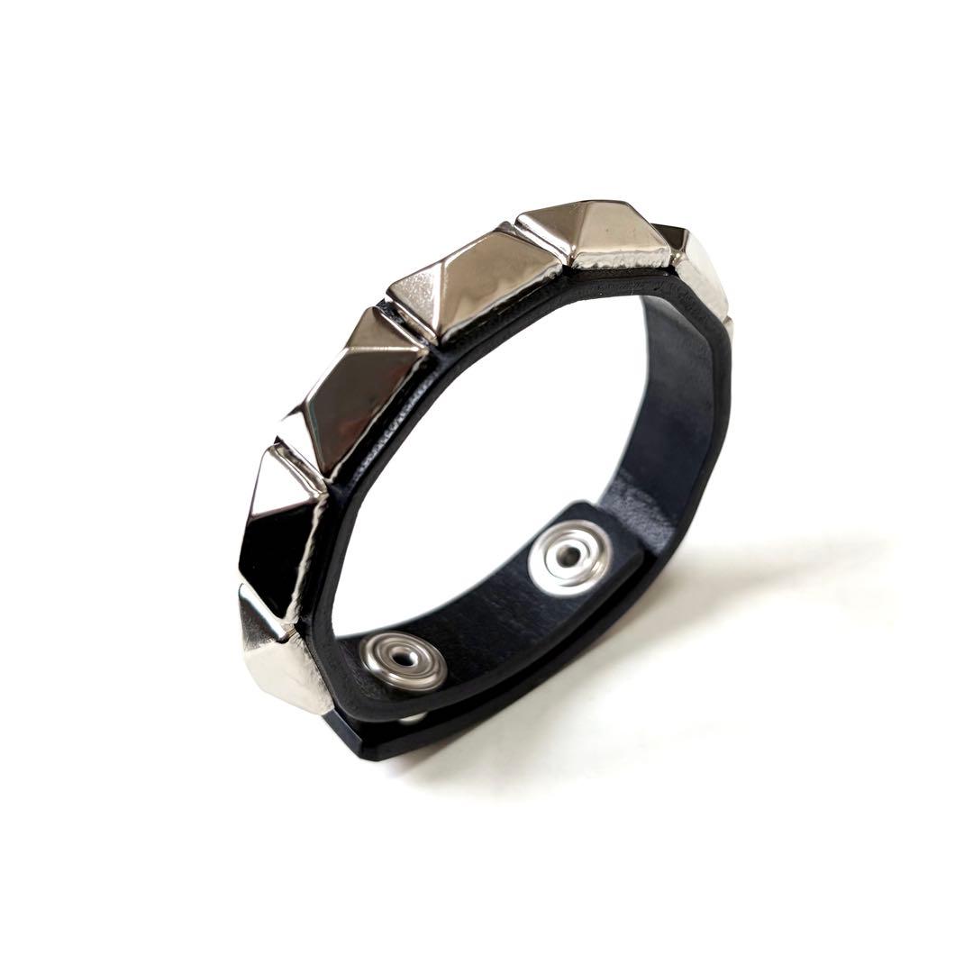 Black cow-leather bracelet with silver pyramid studs and snap closures on a white background.