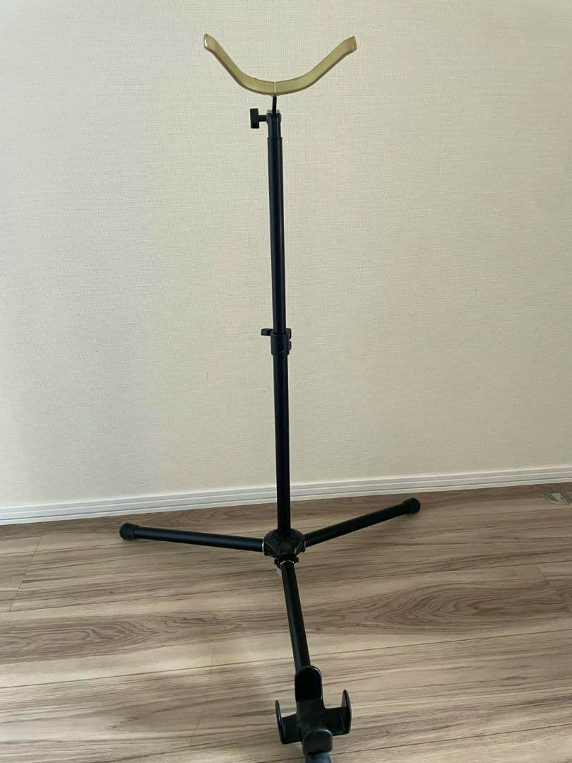 Aida foldable bassoon stand on a floor showing its tripod base and curved yoke.
