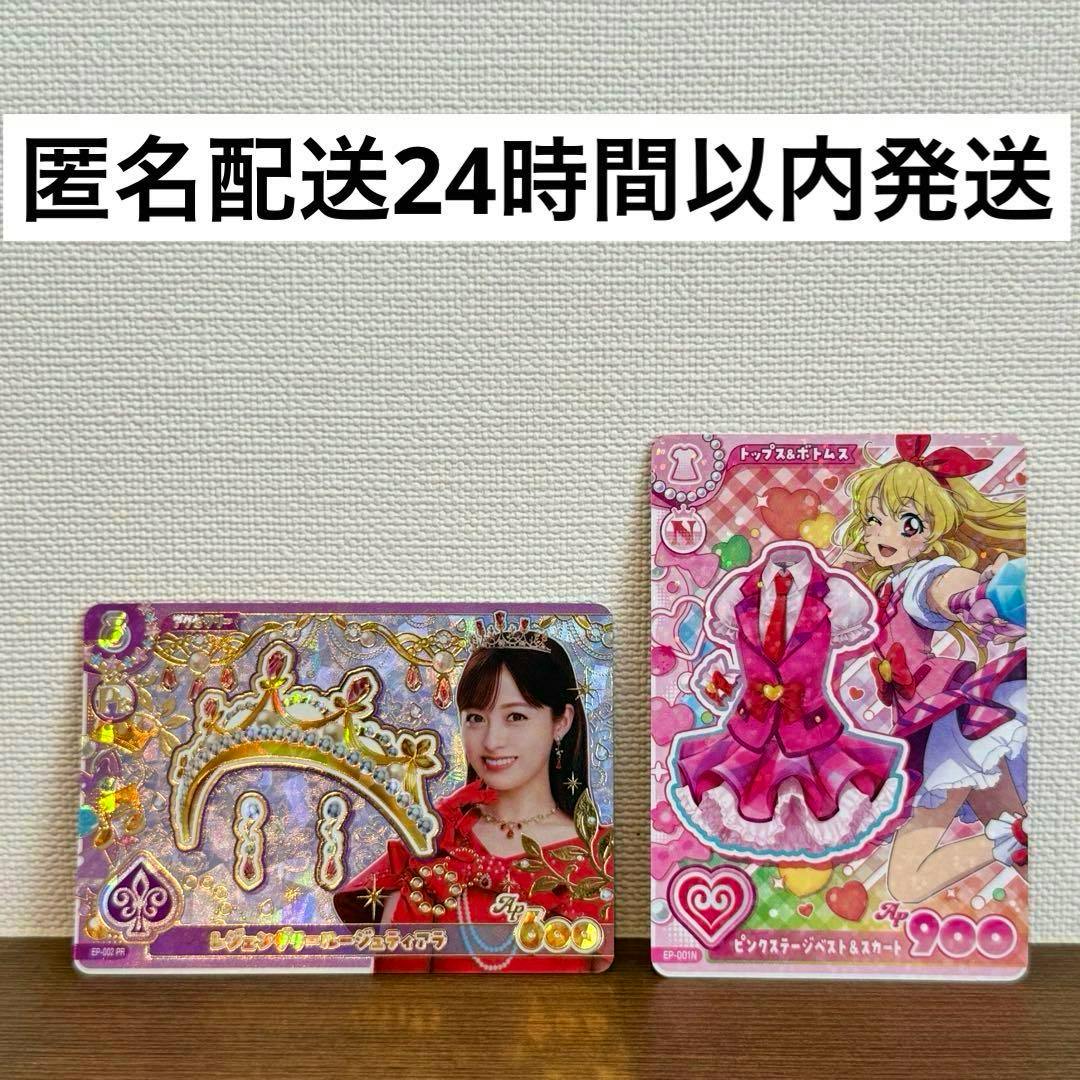 Two Aikatsu trading cards on a tabletop: a tiara card featuring a woman's photo and a pink skirt card.