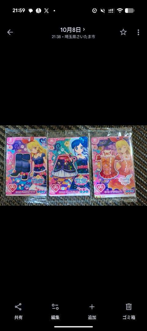 Three Aikatsu! Encore collectible cards in plastic sleeves laid side by side on a textured surface.