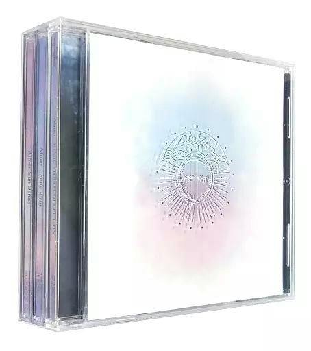 Jewel-case view of Aimer "Sun Dance ＆ Penny Rain" Blu-ray with CD showing a white cover with a central embossed emblem and visible spines.