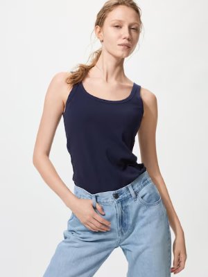 Model wearing a navy Airism cotton bra tank top paired with light blue jeans against a white background.