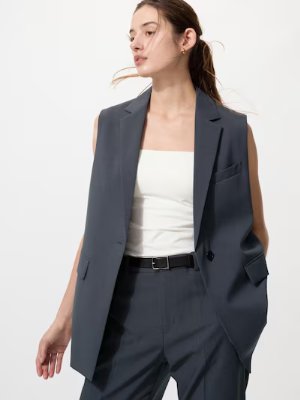 Woman wearing a white tube top styled under a sleeveless blazer.