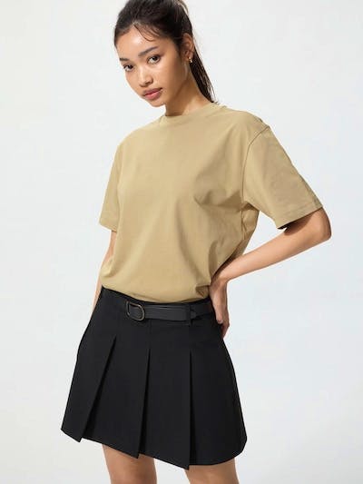Model wearing a beige short-sleeve women's cotton T-shirt visible from the waist up.