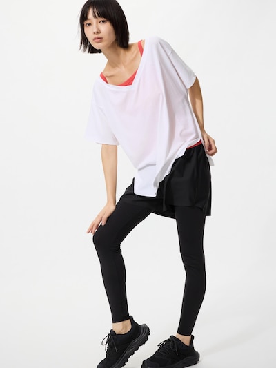 Model wearing black women's leggings paired with a white oversized top and black sneakers.