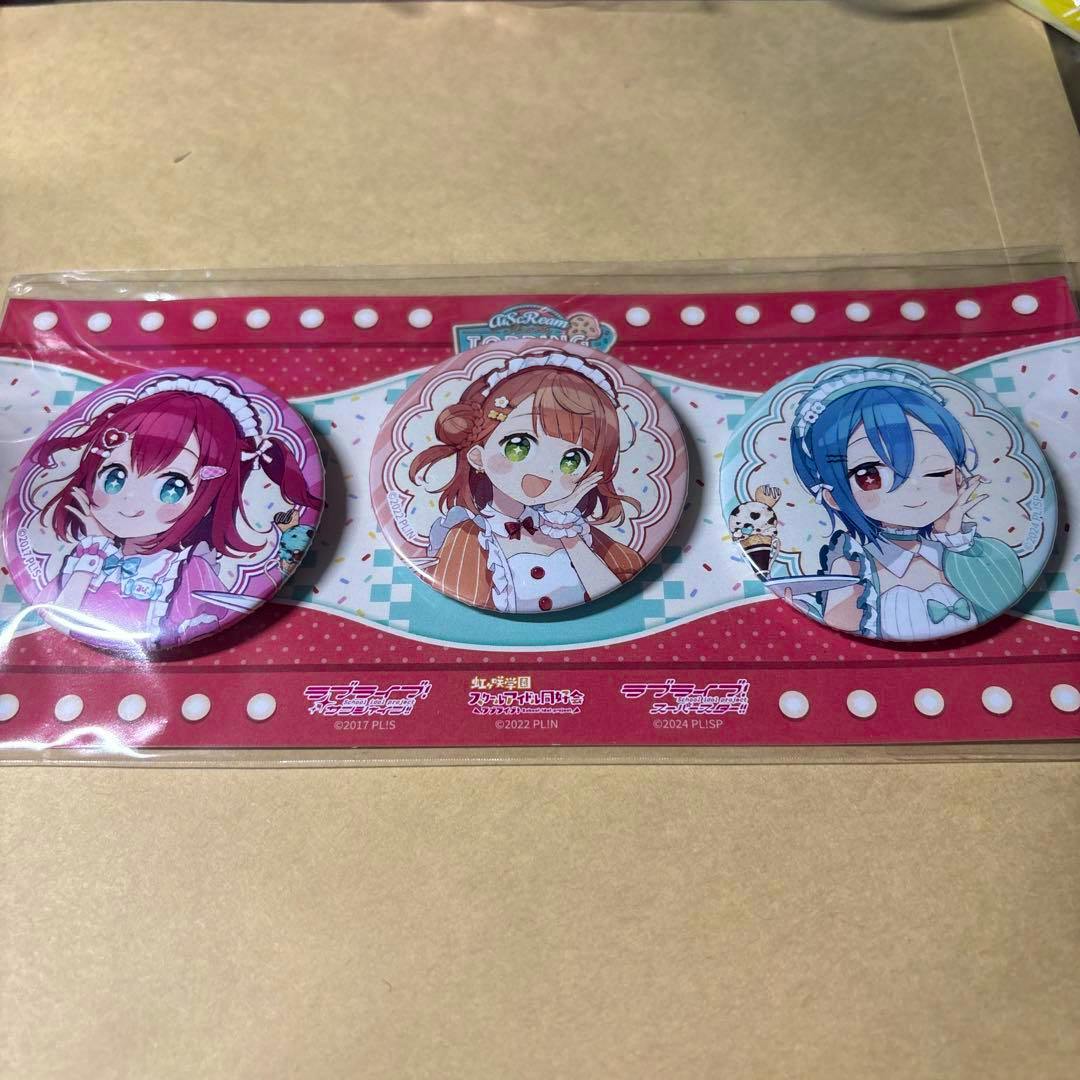 Three AiScReam TOPPING LIVE can badges featuring anime character illustrations in sealed packaging.