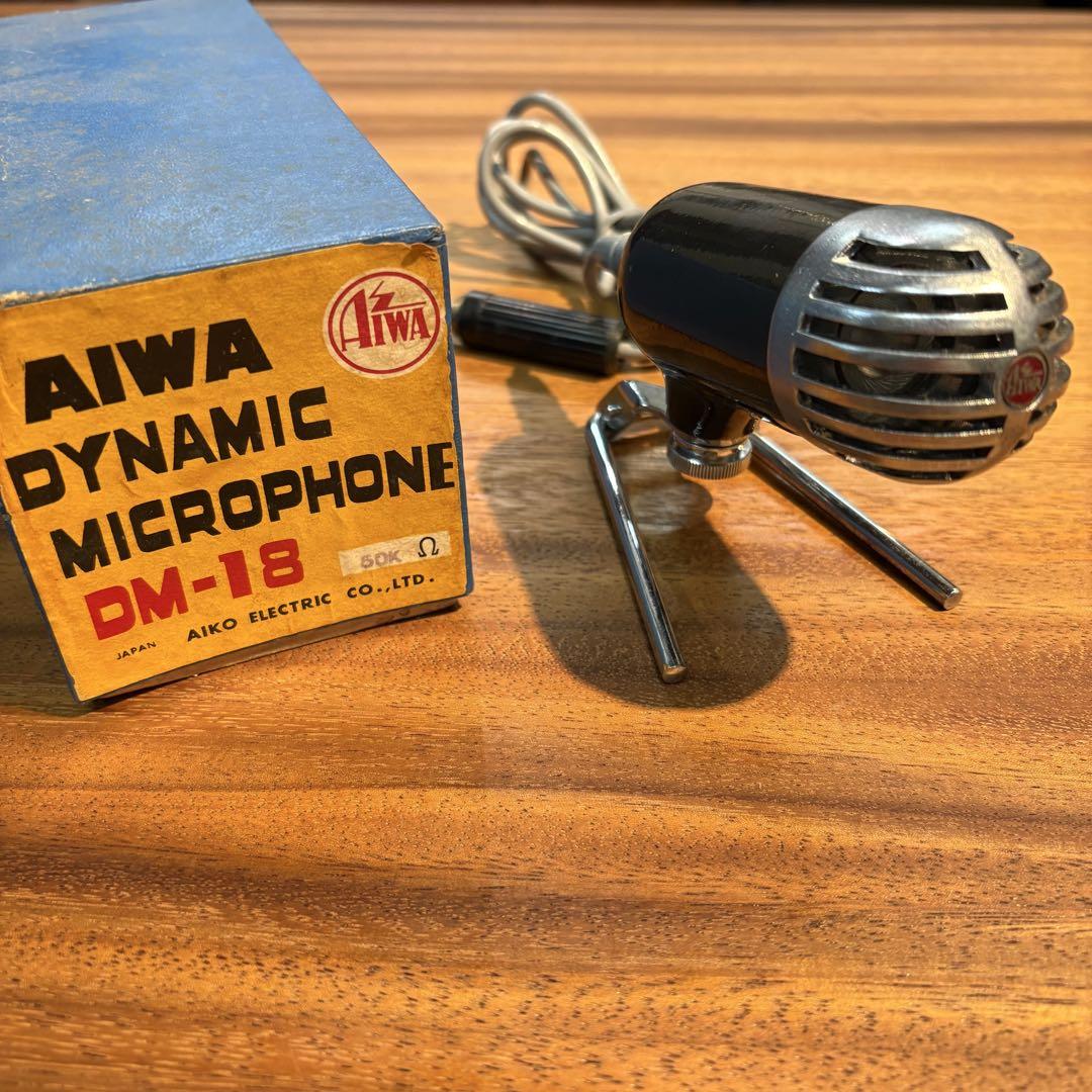 Vintage AIWA dynamic microphone (DM-18) on a wooden surface next to its original box.