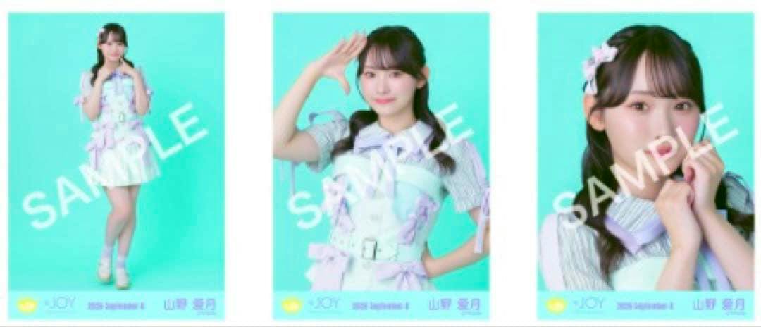 Photocard front: full-body photo of a woman in a pastel stage outfit with twin-tail hairstyle against a mint-green background and a visible "SAMPLE" watermark.