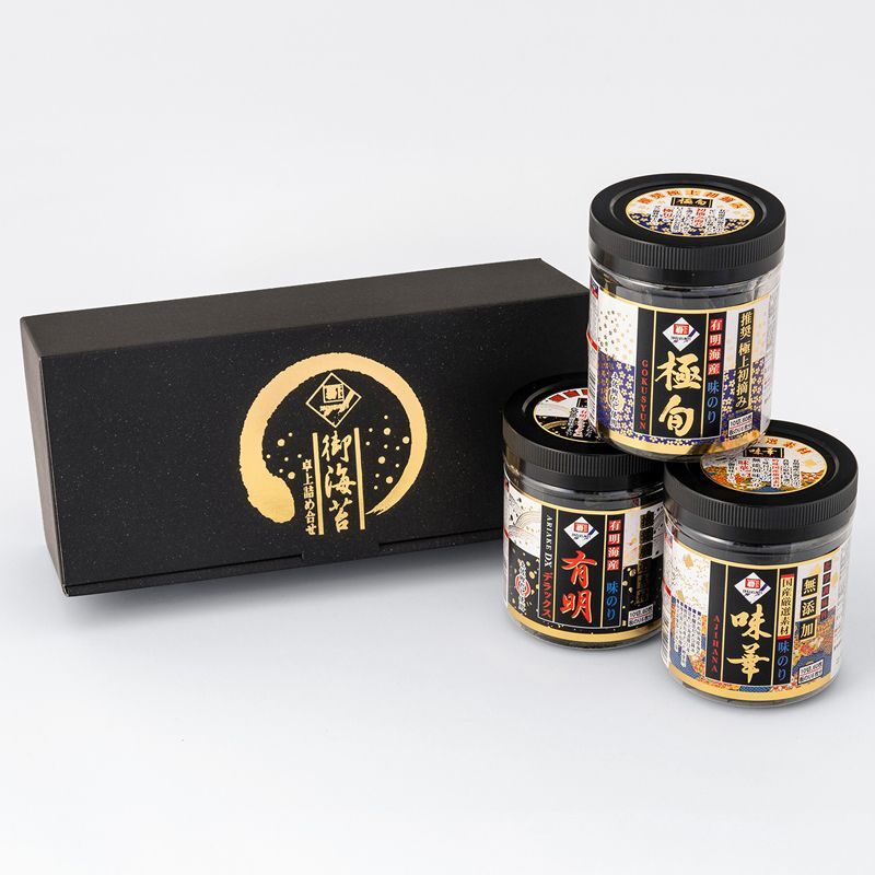 Three jars of seasoned dried seaweed with labels displayed next to a black gift box on a white background.