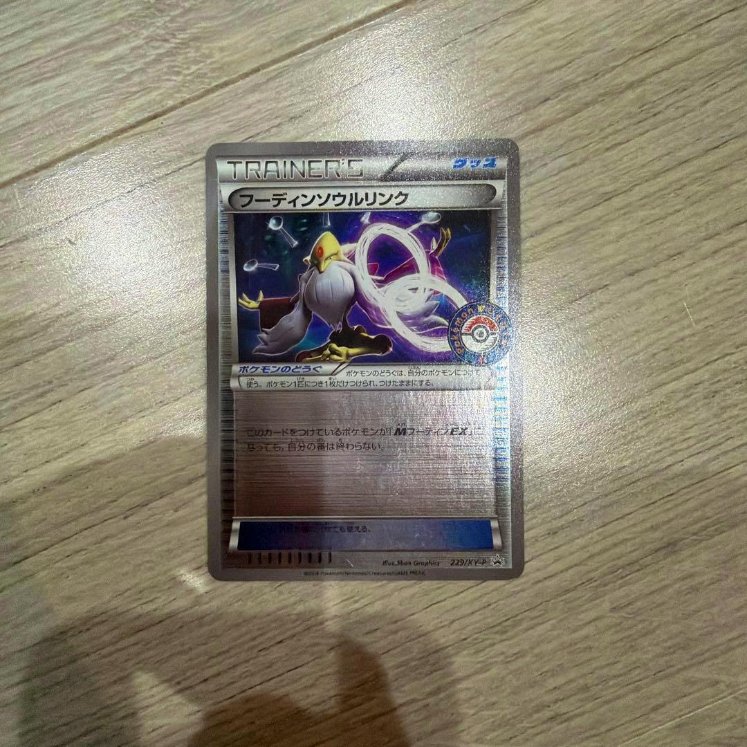 Front of the Japanese フーディンソウルリンク Pokémon trading card (holo Trainer card) photographed on a wooden surface.