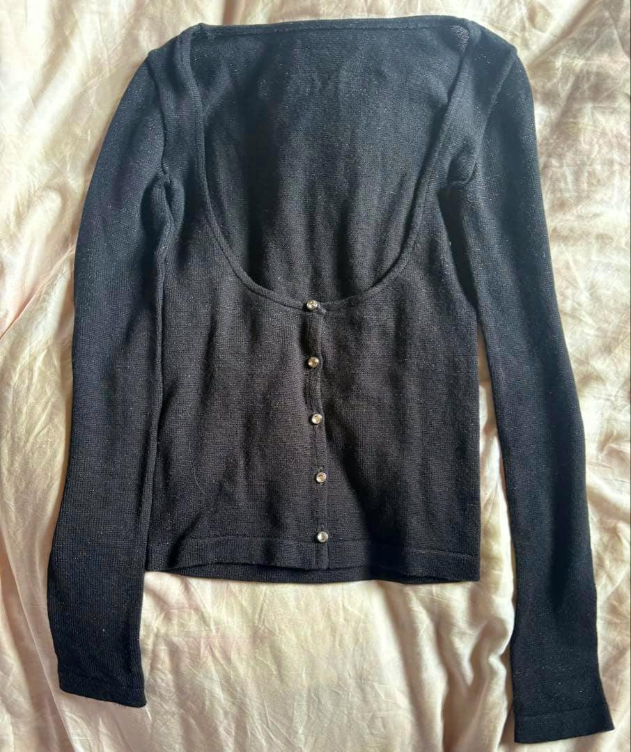 Black long-sleeve cardigan laid flat showing front button closure and subtle sparkle.