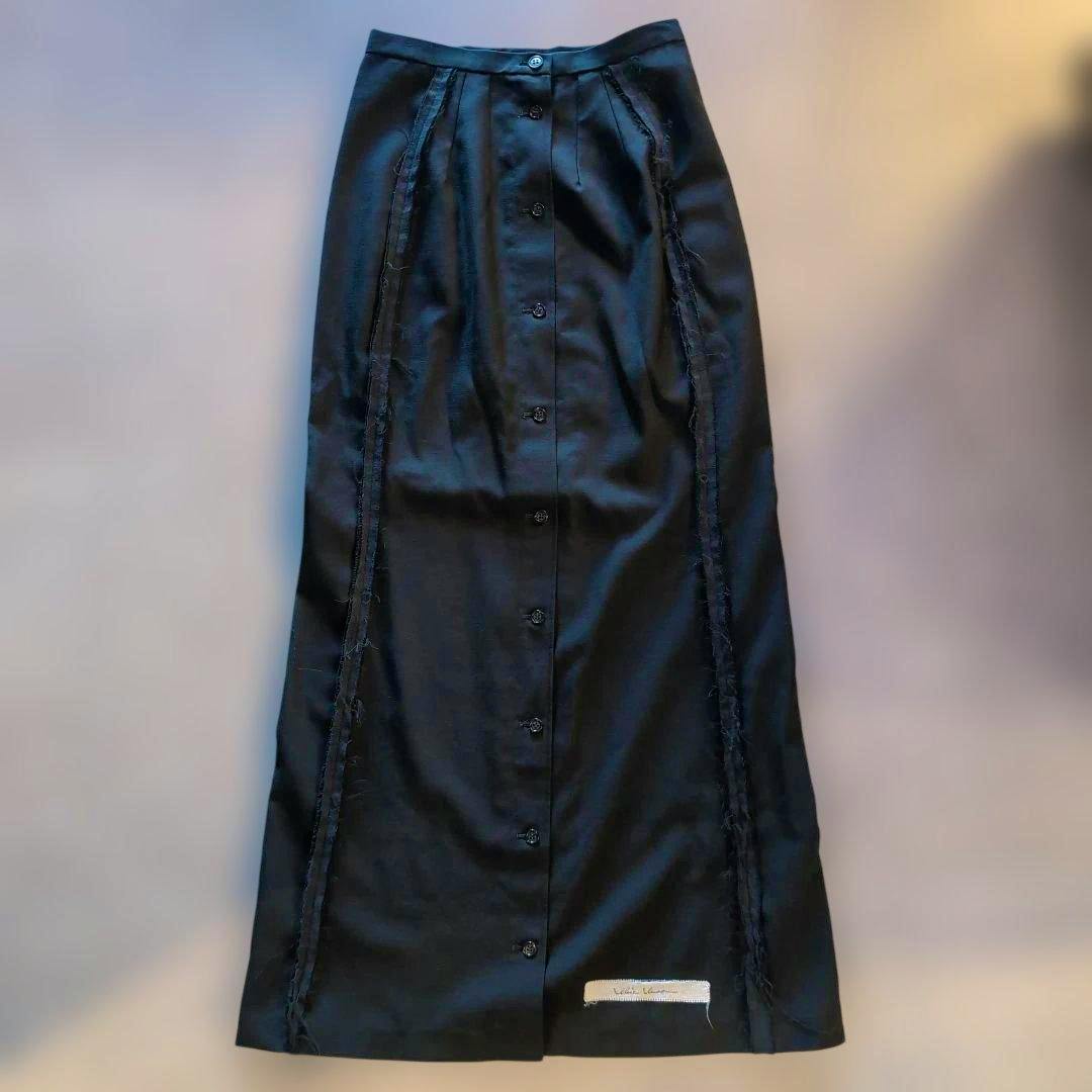 Front view of an alice auaa long skirt laid flat showing center front buttons and fringe side trim.