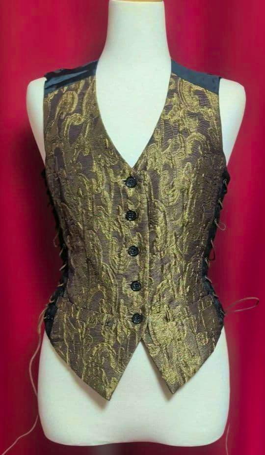 Front view of a brown and gold jacquard vest with five front buttons and lace-up details on both sides displayed on a mannequin.