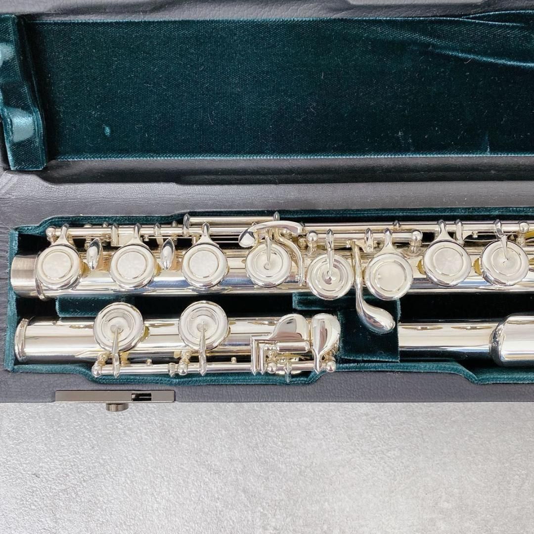 Silver Altus A1107 flute body and keys laid in a green-velvet-lined case.
