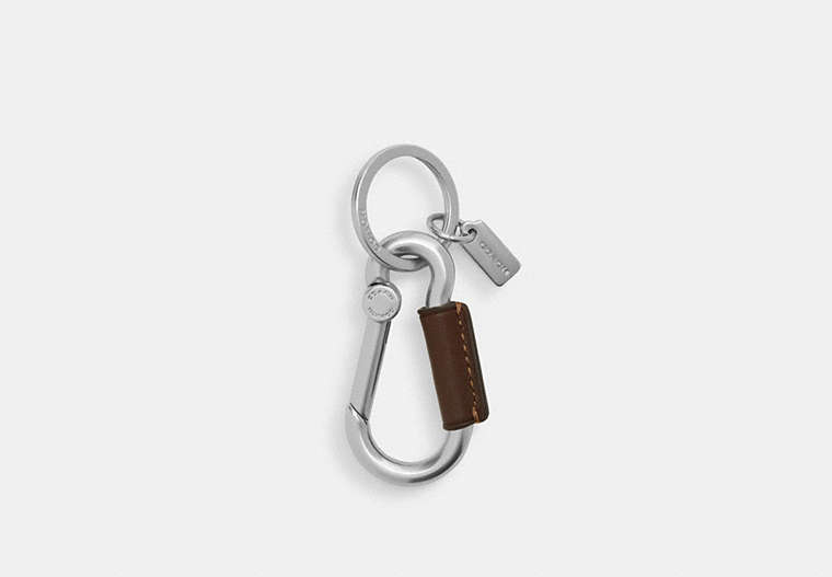 A silver aluminum carabiner key ring with a brown sleeve and a small metal tag on a white background.