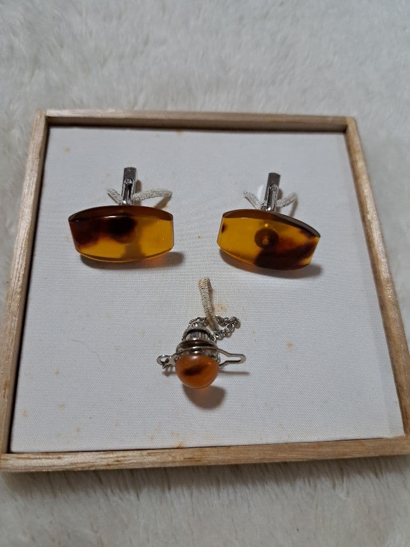 Amber-style cufflinks and a matching tie pin displayed inside a wooden box on a white background.