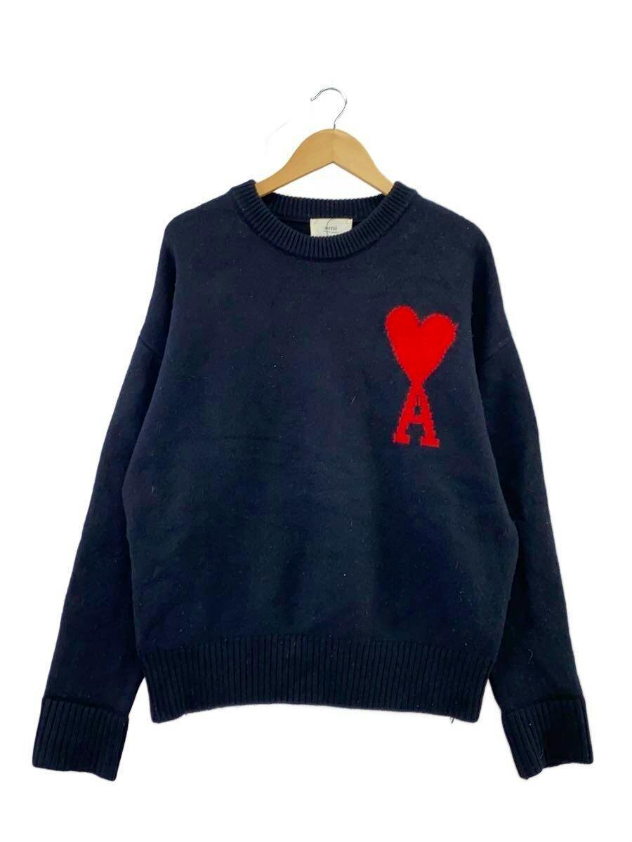 Black wool sweater hanging on a wooden hanger, showing a red heart-shaped logo with the letter A on the chest.
