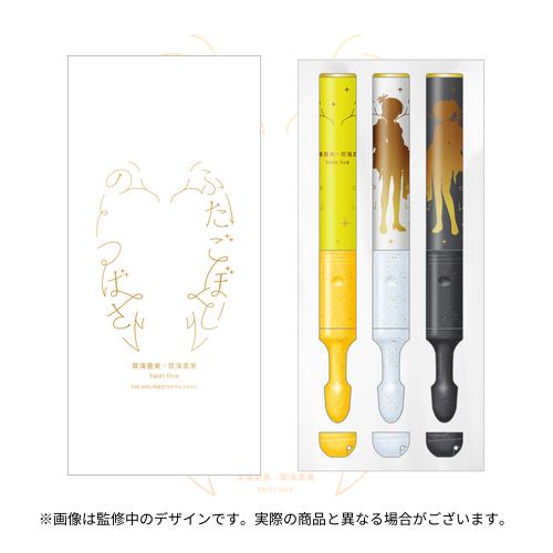 Three concert pen lights (yellow, white, and black) displayed in a plastic tray next to a white product box with gold Japanese text.