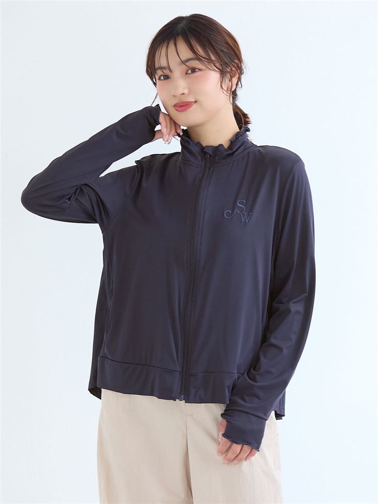 Front view of a woman modeling the dark zip-up women's jacket with logo embroidery and a ruffled collar.