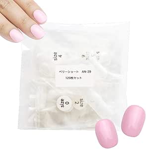 Clear plastic bag of clear nail tips labeled with sizes, shown with two pink sample false nails and a hand holding the pack.