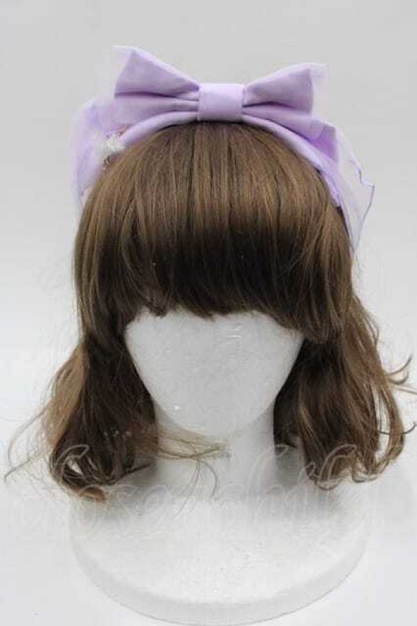 Front view of a lavender Angelic Pretty feather-charm headband with a large bow on a mannequin head.