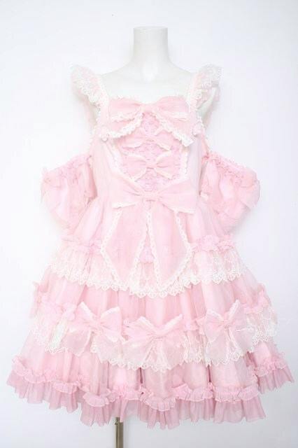 Front view of the pink Angelic Pretty Ribbon Doll dress on a mannequin, showing lace trim, multiple ruffled tiers, bows, and puffed sleeves.