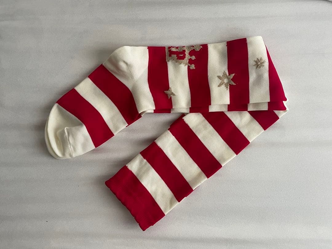 Red-and-white striped over-the-knee women's socks with star and crown motifs laid flat on a white background.