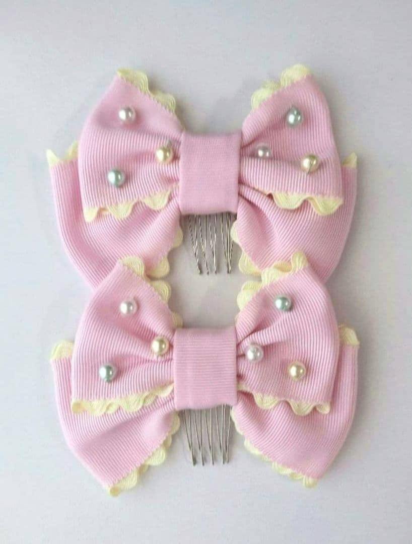 Two pink ribbon hair combs with pastel-colored pearl beads, yellow scalloped trim, and visible metal combs.