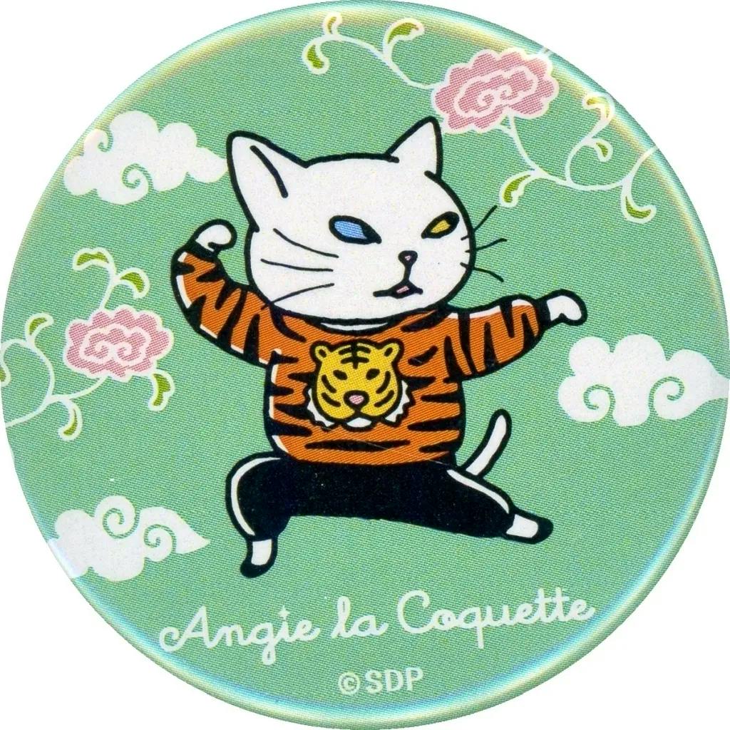 Round can badge depicting a white cat in a tiger-striped sweater striking a kung-fu pose on a green background with decorative clouds and the text "Angie la Coquette".