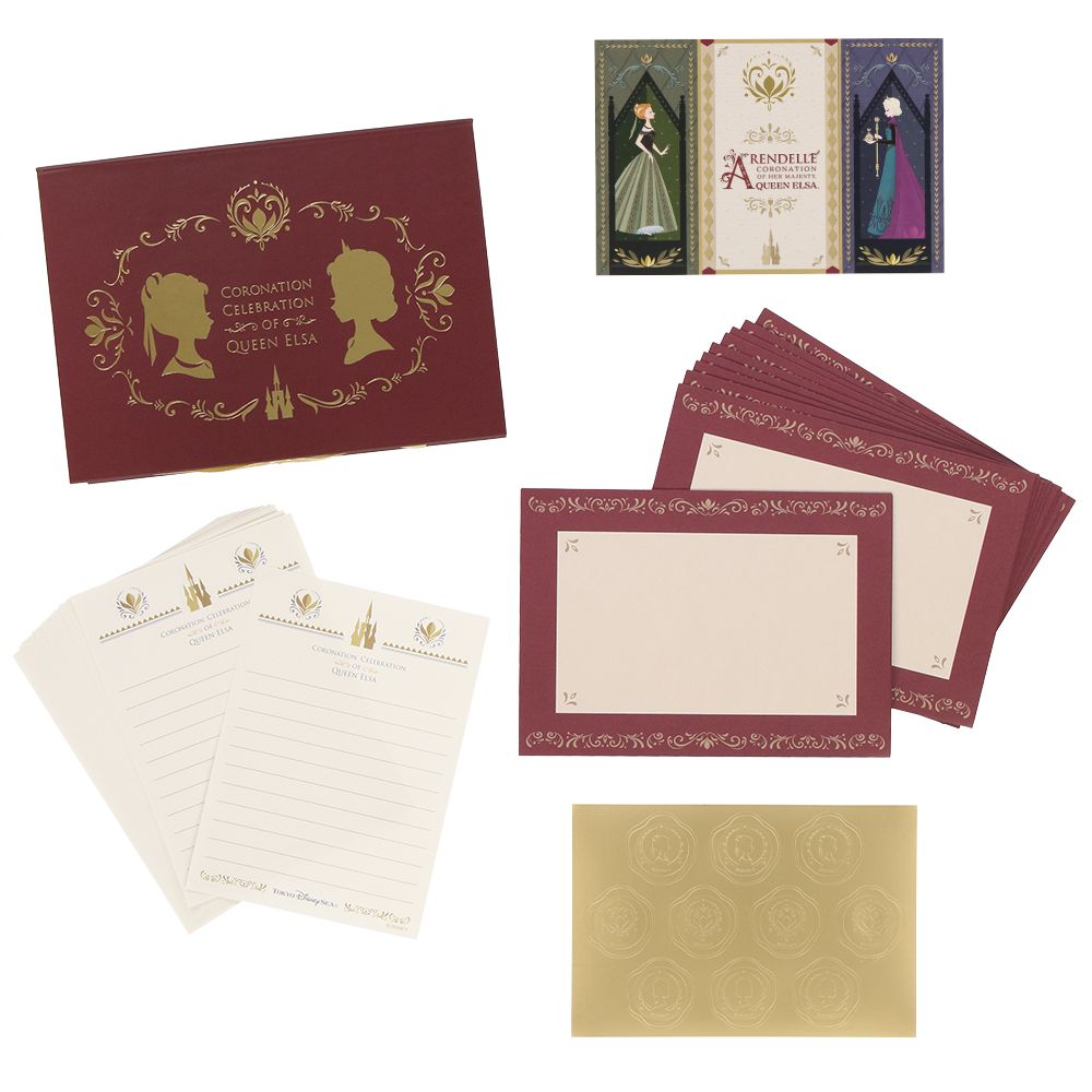 Photo of an Anna and Elsa letter set showing the decorative box, several bordered note cards, lined writing sheets, envelopes, and a gold sticker sheet.