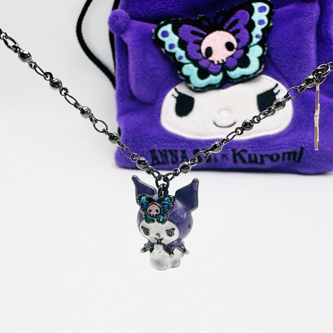Close-up of the ANNA SUI Kuromi necklace pendant on its black chain with the purple Kuromi pouch visible in the background.