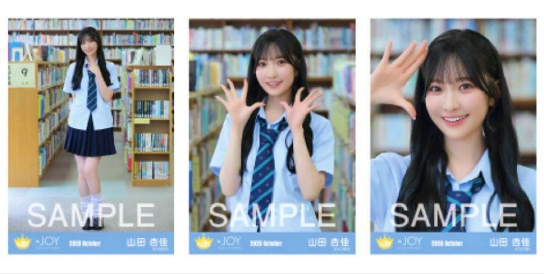Photocard of 山田杏佳 in a school/MV outfit with twin tails standing in a library, full-body pose with a visible "SAMPLE" watermark.