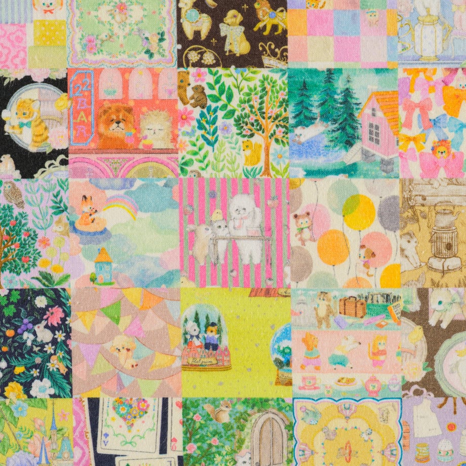 Close-up of multicolor patchwork cotton sheeting showing various small illustrated squares and motifs.